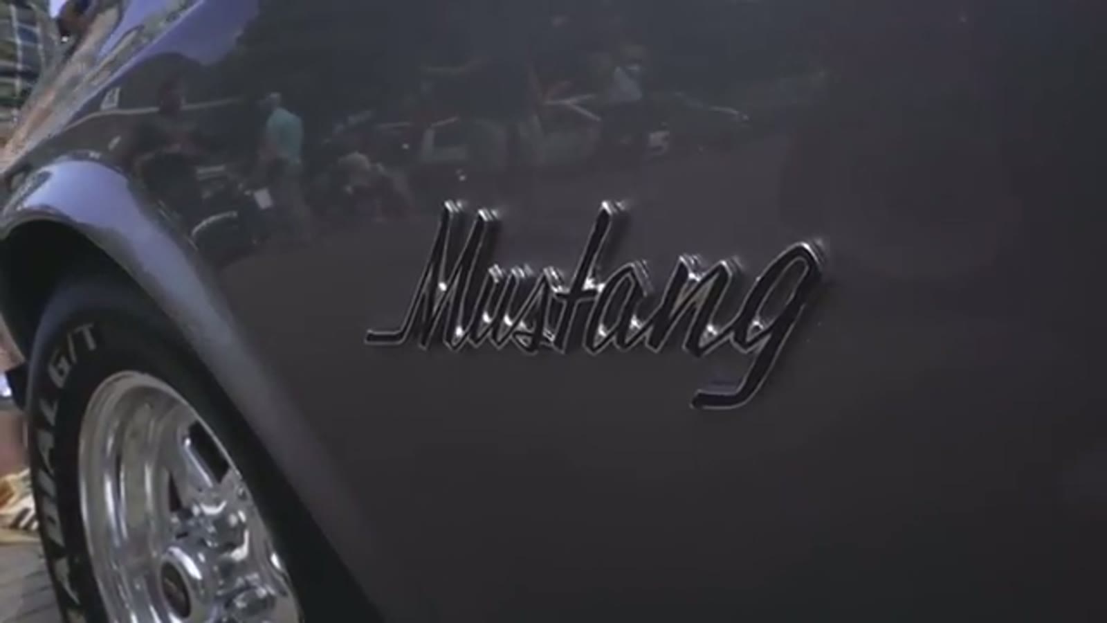 Chromen Mustang-embleem op de flank van een donkere Ford Mustang Coupé uit 1969